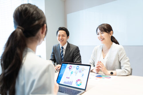 笑顔で会議する会社員達